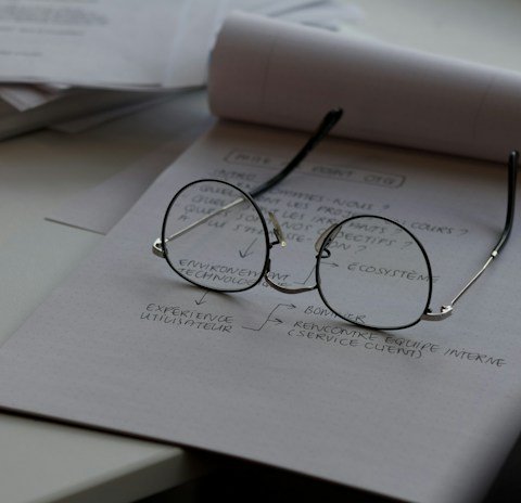 black framed eyeglasses on top of white printing paper