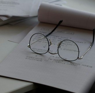 black framed eyeglasses on top of white printing paper